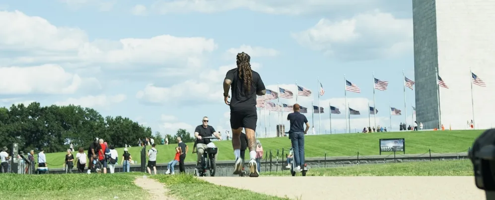 A man runs along the National Mall near the Washington Monument on a sunny day. 